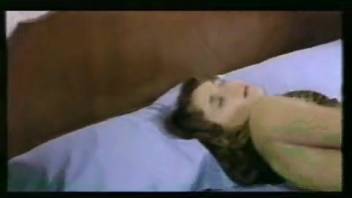 A curly-haired brunette woman pleasures herself solo with a serpent.