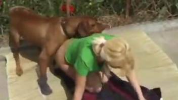 Blonde dressed in green enjoying a dog's dick